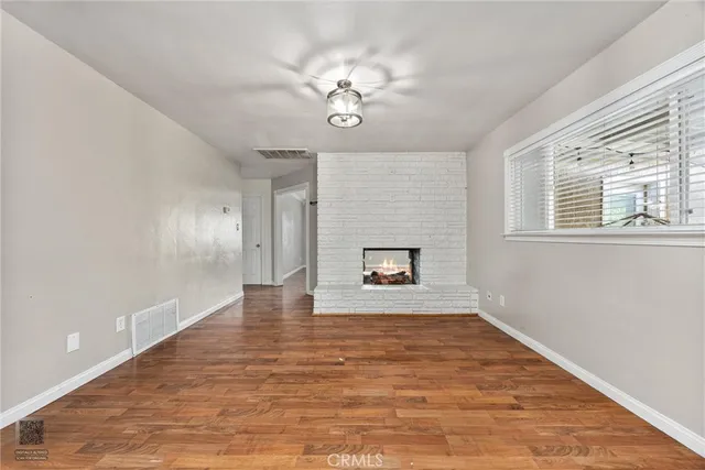 a view of an empty room with a window and a fireplace