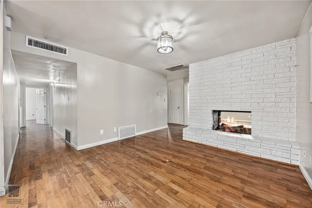 a view of a room with wooden floor and chandelier