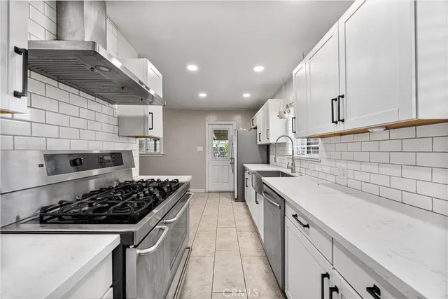 a kitchen with a sink a stove and cabinets