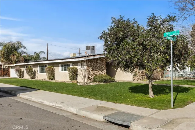 a front view of a house with a yard and trees