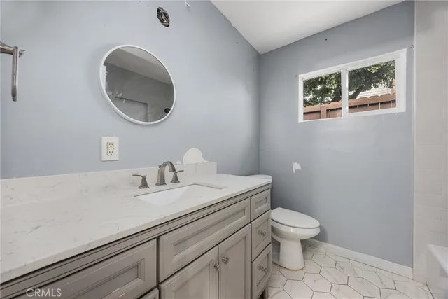 a bathroom with a toilet a sink and mirror