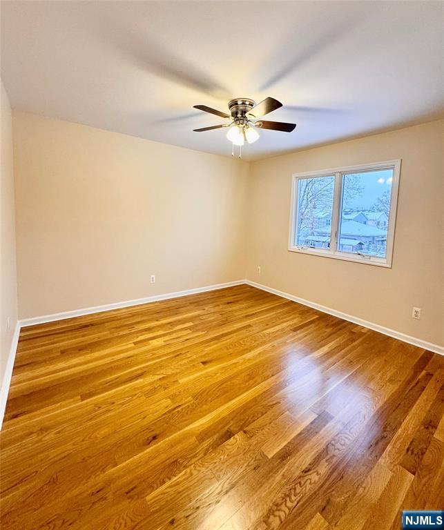 57 Franklin Street, Unit 2 Elmwood Park, NJ 07407 - Photo 14 of 19 a view of an empty room with wooden floor and a ceiling fan