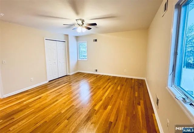 a view of a room with wooden floor and ceiling fan