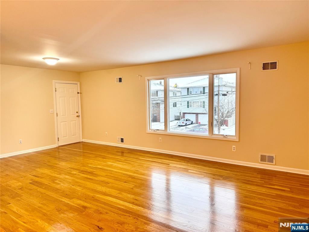 57 Franklin Street, Unit 2 Elmwood Park, NJ 07407 - Photo 4 of 19 a view of an empty room with wooden floor and a window