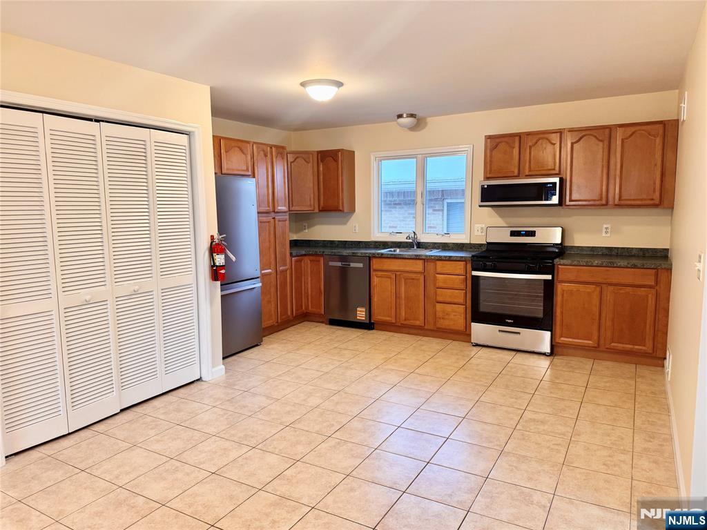 57 Franklin Street, Unit 2 Elmwood Park, NJ 07407 - Photo 7 of 19 a kitchen with stainless steel appliances granite countertop a stove top oven a sink a counter space and cabinets