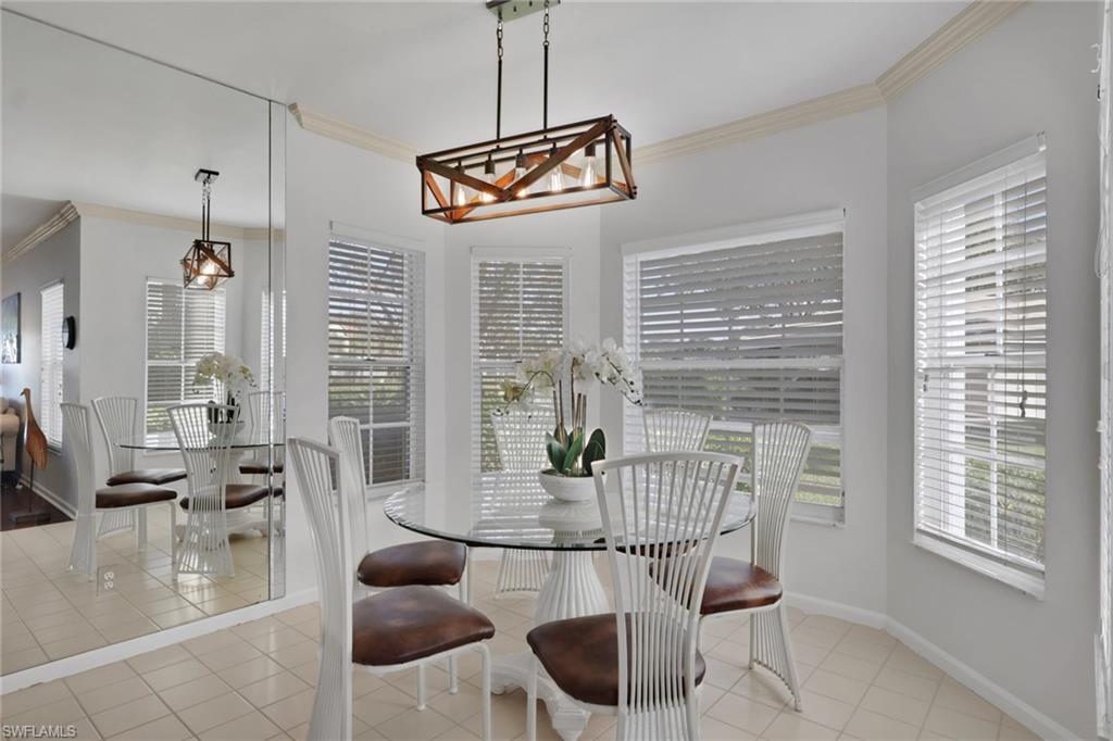 6260 Bellerive Avenue, Unit 4 Naples, FL 34119 - Photo 11 of 27 a dining room with furniture and wooden floor