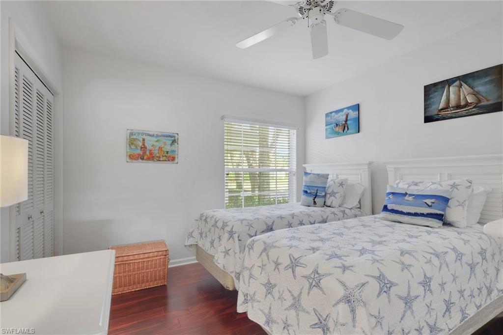 6260 Bellerive Avenue, Unit 4 Naples, FL 34119 - Photo 14 of 27 a bedroom with a bed and a chandelier