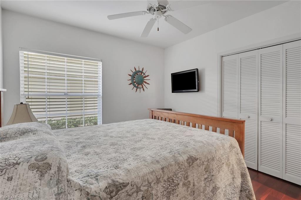 6260 Bellerive Avenue, Unit 4 Naples, FL 34119 - Photo 20 of 27 a bedroom with a large bed and a flat screen tv
