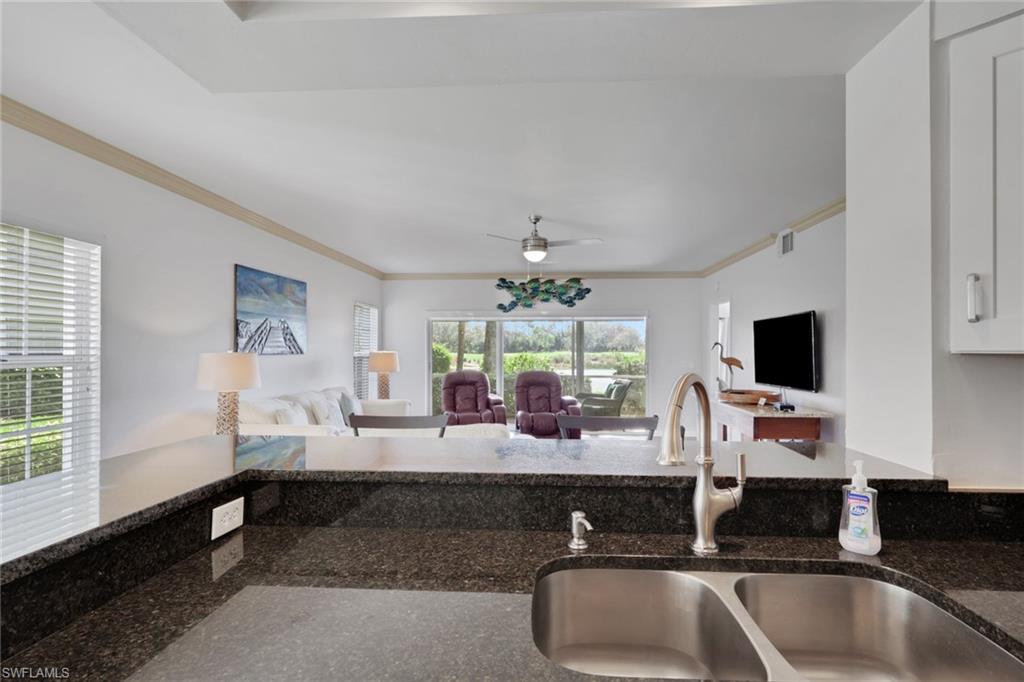 6260 Bellerive Avenue, Unit 4 Naples, FL 34119 - Photo 27 of 27 a room with two sinks and a flat screen tv