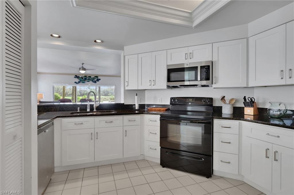 6260 Bellerive Avenue, Unit 4 Naples, FL 34119 - Photo 8 of 27 a kitchen with white cabinets and appliances