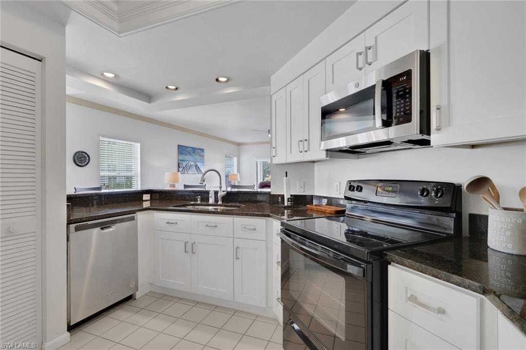 6260 Bellerive Avenue, Unit 4 Naples, FL 34119 - Photo 9 of 27 a kitchen with stainless steel appliances granite countertop a sink stove and microwave