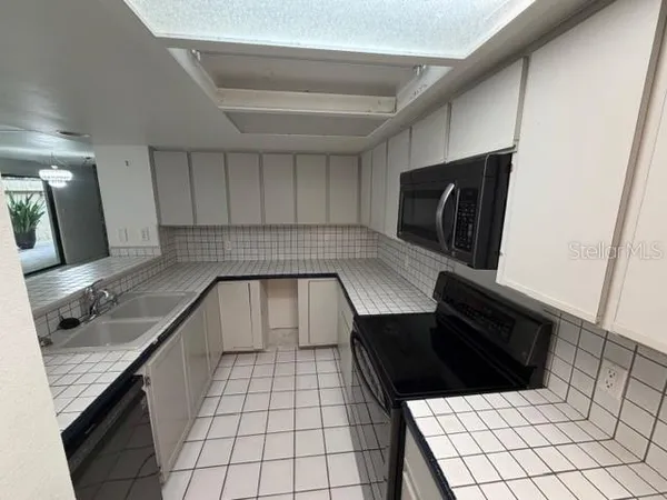 a kitchen with a sink a stove and cabinets