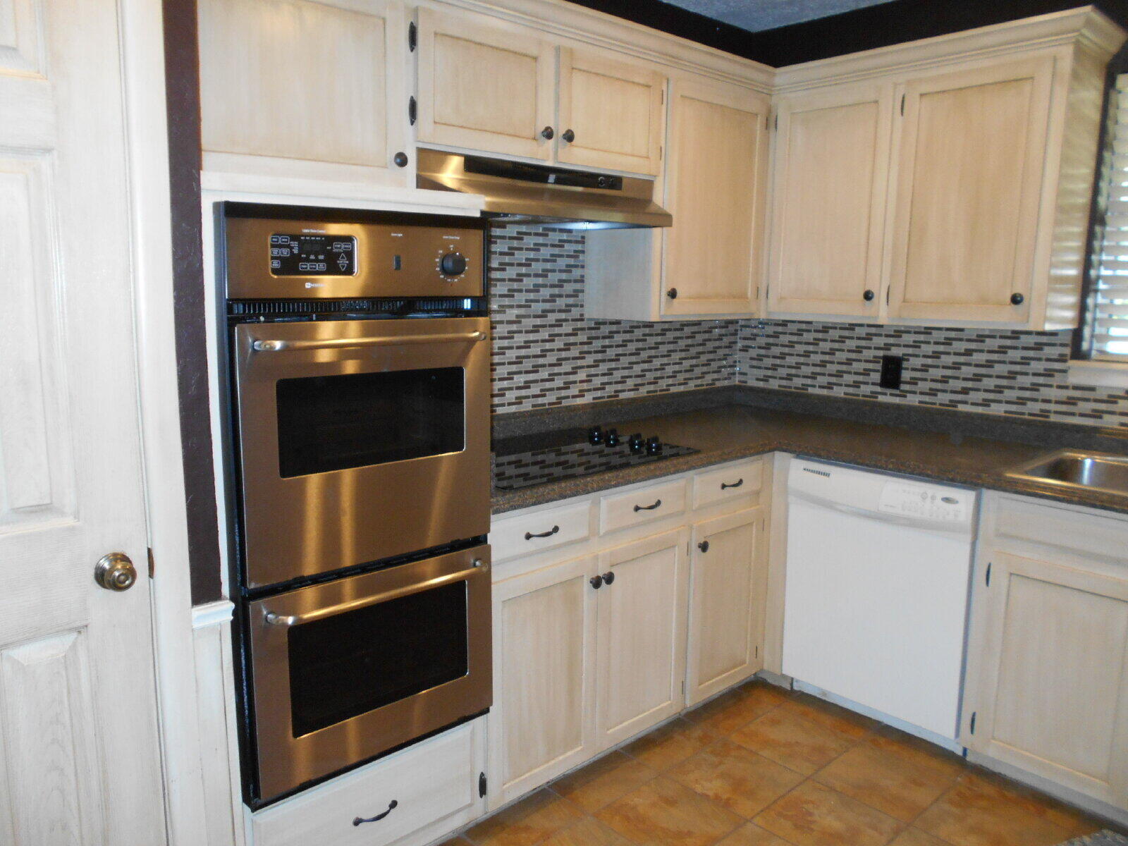 4431 77th Street Lubbock, TX 79424 - Photo 4 of 19 a kitchen with granite countertop white cabinets stainless steel appliances and sink