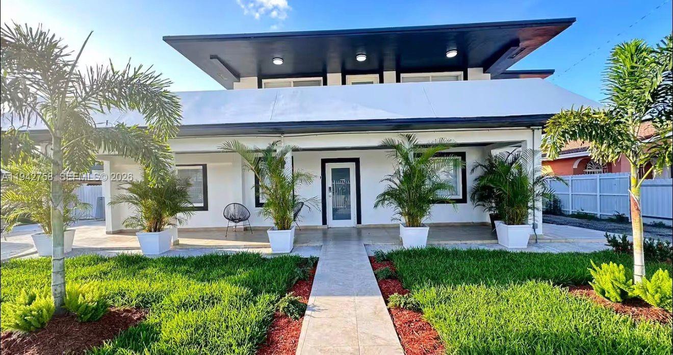 a front view of a house with garden and plants