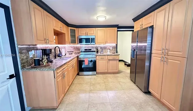 a kitchen with stainless steel appliances granite countertop a refrigerator and a stove top oven