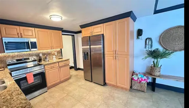 a kitchen with stainless steel appliances granite countertop a refrigerator and a stove