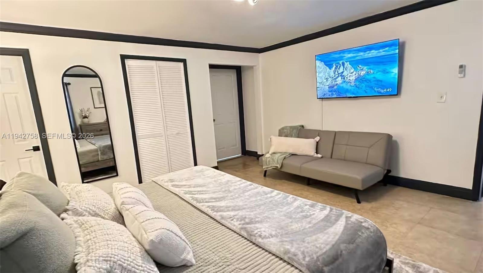 747 East 19th Street Hialeah, FL 33013 - Photo 16 of 37 a bedroom with a couch painting on the wall and a large window