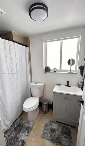 a bathroom with a toilet a sink and a window