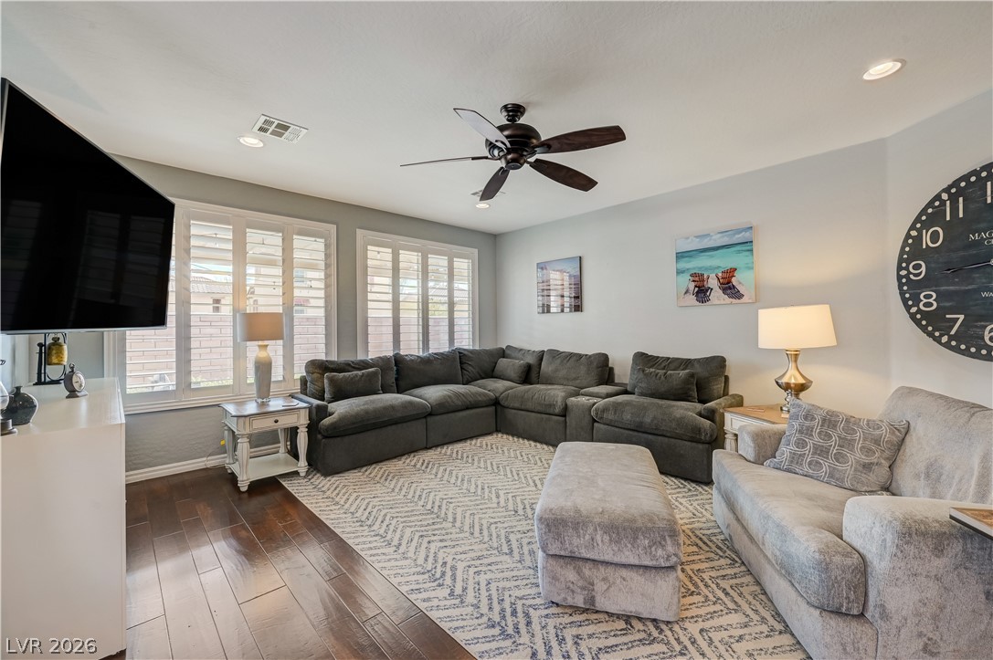 7049 Motley Road Las Vegas, NV 89178 - Photo 19 of 61 Rich wood-inspired floors and classic plantation shutters define this welcoming living space.