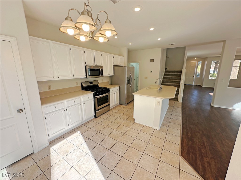 181 Ruby Ridge Avenue Henderson, NV 89002 - Photo 11 of 44 Kitchen featuring stainless steel appliances, white cabinets, light countertops, recessed lighting, and a chandelier