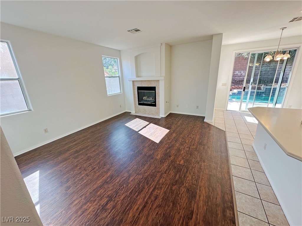 181 Ruby Ridge Avenue Henderson, NV 89002 - Photo 6 of 44 Unfurnished living room featuring light wood-style flooring and a tiled fireplace