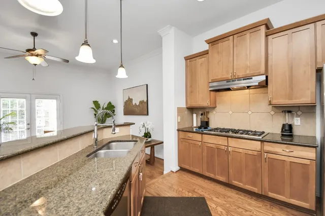 a kitchen with kitchen island granite countertop wooden cabinets and a stove