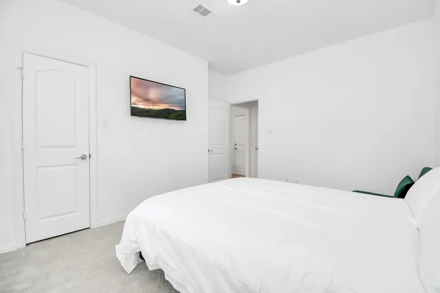 a bedroom with a bed and a painting on the wall