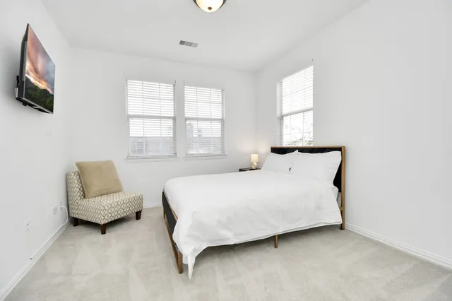 a bedroom with a bed couch and window