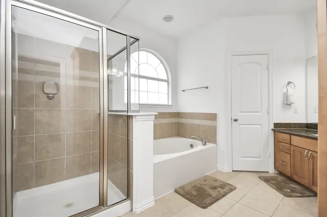a bathroom with a tub a sink and a mirror