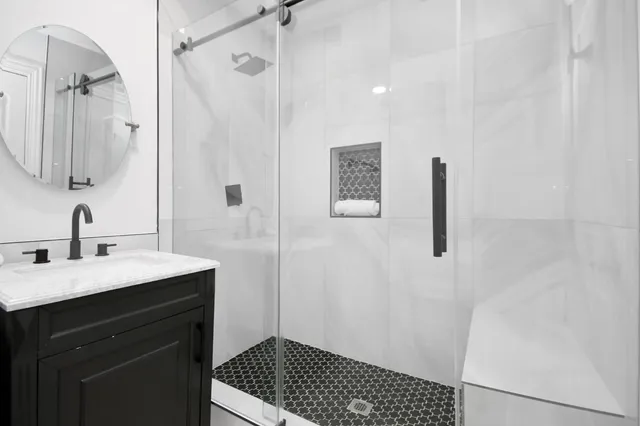 a bathroom with a sink a toilet a shower and a mirror