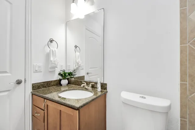a bathroom with a granite countertop sink and a mirror