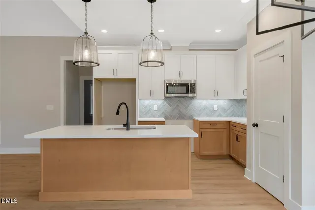 a large kitchen with stainless steel appliances granite countertop a sink a stove and a refrigerator