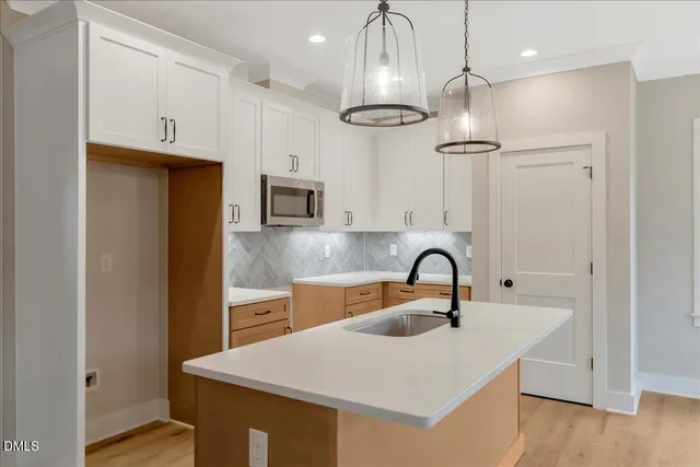 a kitchen with stainless steel appliances a sink a refrigerator a stove a microwave and cabinets