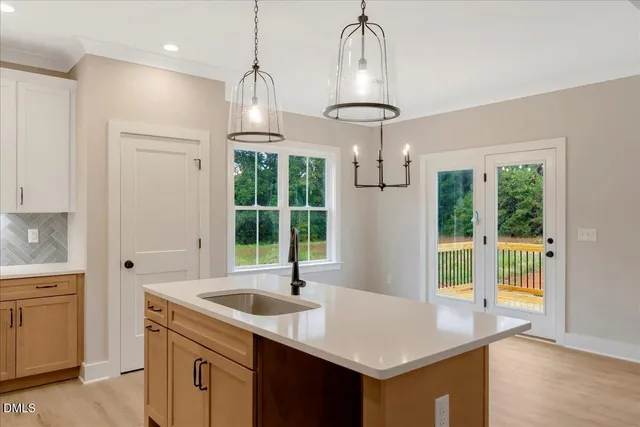 a kitchen with a sink a center island and a window