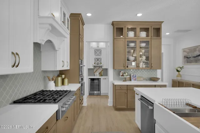 a large white kitchen with lots of counter space wooden floor and appliances