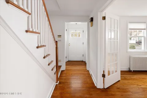 a view of a hallway with wooden floor and staircase