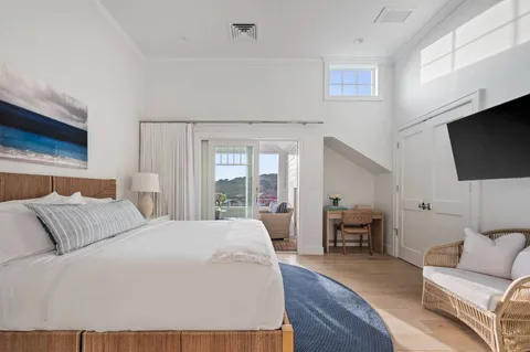 a bedroom with a bed a flat screen tv and a couch