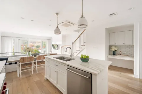 a kitchen with white cabinets and sink