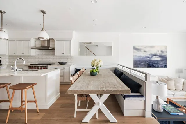 a kitchen with stainless steel appliances kitchen island a stove a table and chairs in it
