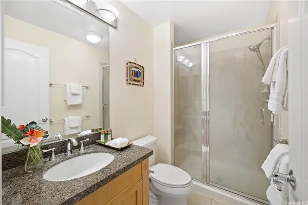 a bathroom with a granite countertop sink toilet a mirror and shower