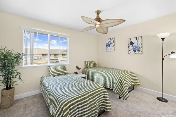a bedroom with two beds and a potted plant