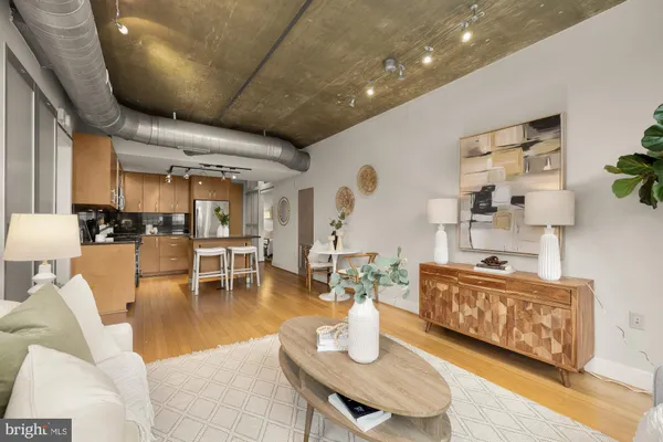 a living room with furniture a table and kitchen view