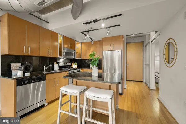 a kitchen with stainless steel appliances granite countertop a refrigerator a stove top oven a sink and dishwasher