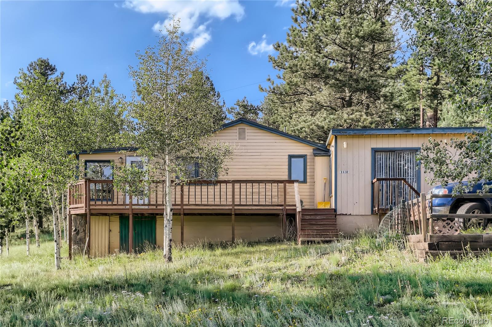 297 Neal Road Bailey, CO 80421 - Photo 1 of 17 a view of a house with a wooden deck and a yard