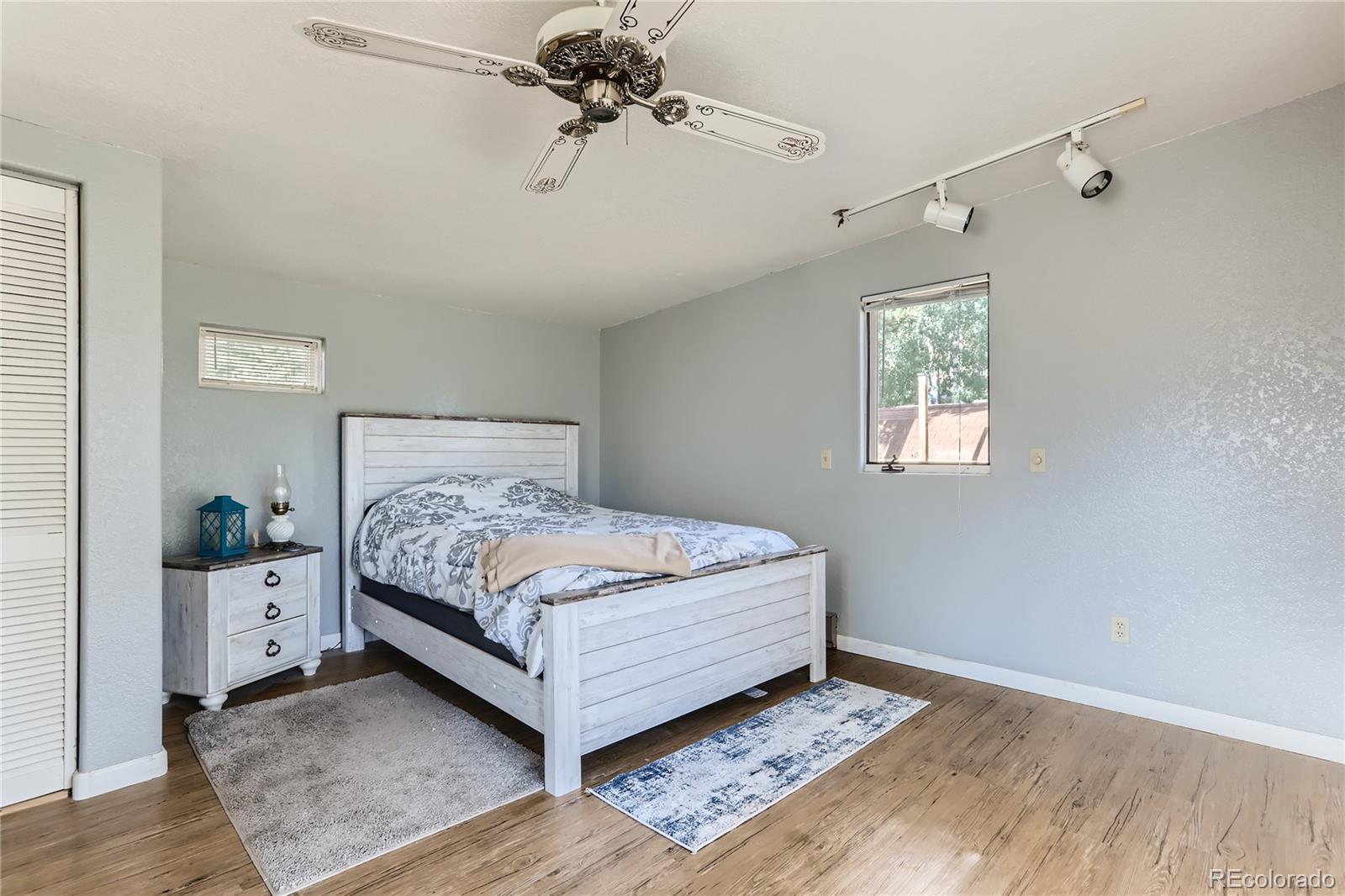 297 Neal Road Bailey, CO 80421 - Photo 6 of 17 a bed sitting in a bedroom next to a window and a chandelier fan