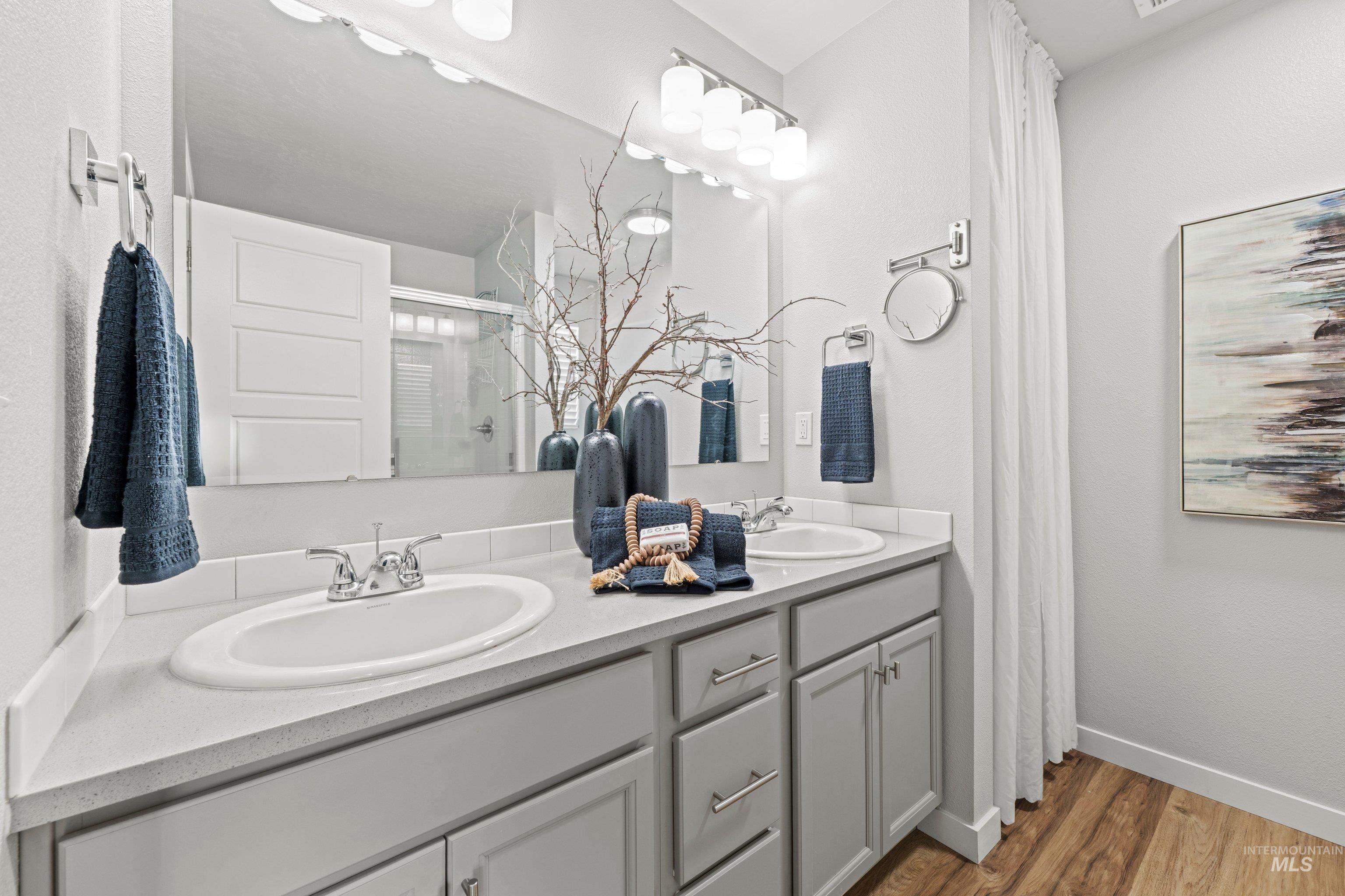 12744 West Fig Street Boise, ID 83713 - Photo 27 of 34 Double vanity with integrated sinks, light gray cabinetry, and modern chrome fixtures
