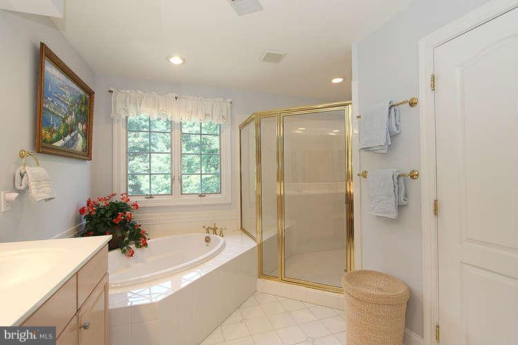 2038 Lord Fairfax Road Vienna, VA 22182 - Photo 11 of 24 a bathroom with a tub shower sink and mirror