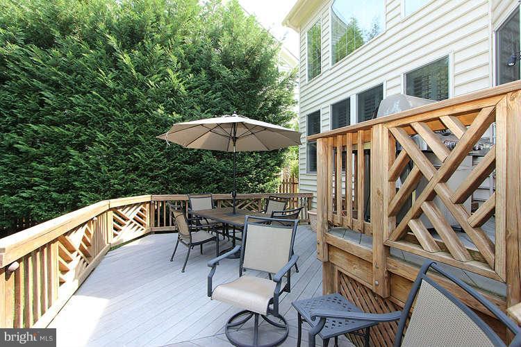 2038 Lord Fairfax Road Vienna, VA 22182 - Photo 21 of 24 a view of a patio with a table and chairs under an umbrella with wooden fence