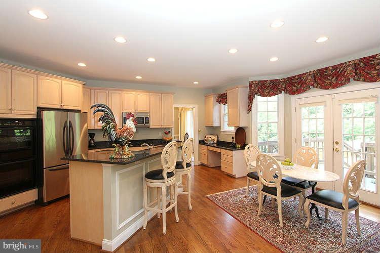2038 Lord Fairfax Road Vienna, VA 22182 - Photo 6 of 24 a view of a dining room with furniture a kitchen and chandelier