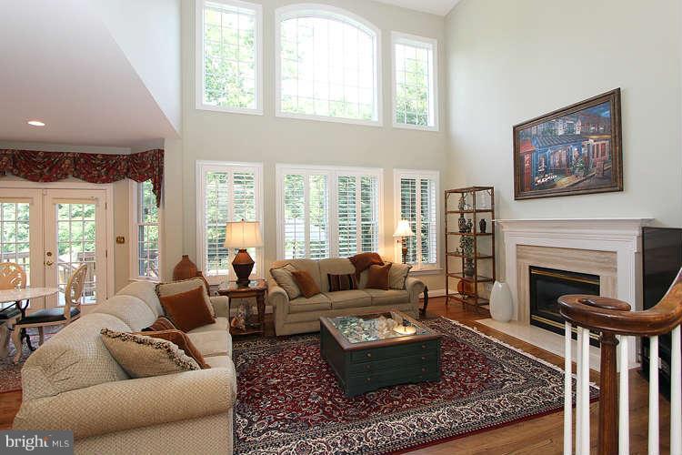 2038 Lord Fairfax Road Vienna, VA 22182 - Photo 7 of 24 a living room with furniture a rug a fireplace and windows